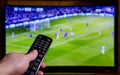 Watching Football on TV and using remote controller Royalty Free Stock Photo