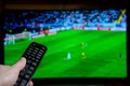 Watching Football on TV and using remote controller Royalty Free Stock Photo