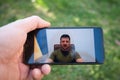 Watching on smartphone Ukraine president Volodymyr Zelensky speaking to the world of the war with Russia