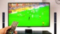 Watching soccer at home tv with remote control on hand Royalty Free Stock Photo