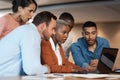 Watching stocks rise and fall will do this to you. a group of young businesspeople using a laptop at a conference in a Royalty Free Stock Photo