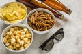 Watching TV with chips, beer and glasses on stone background