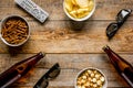 Watching TV with chips, beer and remote control on wooden background top view mock up