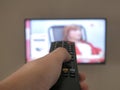 Watching TV, close up of hand hold tv remote controller towards to television