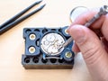 Watchmaker fixes clockwork of mechanical watch