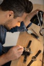 watchmaker repairing mechanical watches in workshop