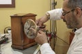 Watchmaker repairs mantelclock in his laboratory