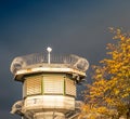 Watchtower of a correctional facility of a prison with a balustrade and two rows of barbed wire rolls in front of a dramatic sky. Royalty Free Stock Photo