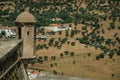 Watchtower on a fortress wall in front of farmhouses and trees