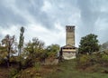 Watchtower - Koshki  and mountain slopes covered with forests and low thunderclouds in Svaneti in the mountainous part of Georgia Royalty Free Stock Photo