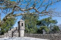 The watchtower of the old castle in Portugal surrounded by trees against the blue sky on a clear Sunny day Royalty Free Stock Photo