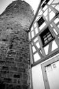 Medieval watchtower next to half-timbered house in black and white