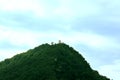 A watchtower on the top of a tall green mountain.