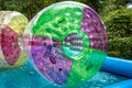 Water or aqua zorbing. Children play inside the inflatable transparent roller floating in swimming pool. Water walking or zorbing