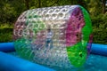 Water or aqua zorbing. Children play inside the inflatable transparent roller floating in swimming pool. Water walking or zorbing