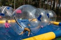 Water or Aquazorbing. Children play inside the inflatable transparent ball floating in swimming pool. Water walking or zorbing Royalty Free Stock Photo