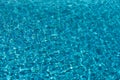 Water background. Blue water, ripples and highlights. Texture of water surface and tiled bottom.