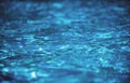 Water background. Blue water, ripples and highlights. Texture of water surface and tiled bottom.