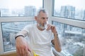 A bearded mature man drinking water from a glass