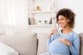 Water balance. Pregnant woman drinking water at home