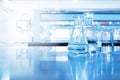 Water in beaker and flask glass in chemistry blue science laboratory background Royalty Free Stock Photo