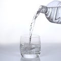 Water being poured into Glass against White Background Royalty Free Stock Photo