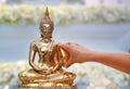 Water blessing ceremony for Songkran Festival or Thai New Year. People paying respects to a statue of Buddha by pouring water onto