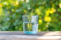 Water blue glass on wooden table with blurred background. Clear, clean water in a glass Royalty Free Stock Photo