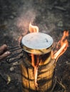 Water boiling in a metal pot on Swedish Fire Log. Burning a Swedish candle, swedish torch in summer Royalty Free Stock Photo