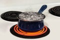 Water Boiling Out of Blue Pot On Stove With Copy Space Royalty Free Stock Photo