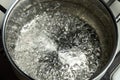 Water boils in a stainless steel pot. Boiling water