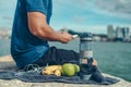 Water bottle, banana, earphone, green apple and towel on the ground beside young man rest after exercise and playing mobile phone Royalty Free Stock Photo