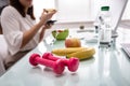 Water Bottle, Banana And Pink Dumbbells On Office Desk