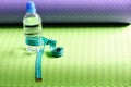 Water bottle and flexible ruler in blue on yoga mat Royalty Free Stock Photo