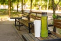 Water bottle and a thermos cup are placed on a table in a picturesque park setting