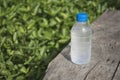 Water bottle on wood table with nature background.