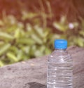 Water bottle on wood table with nature background.