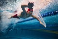 Water bubbles demonstrating speed. Young man, swimming athlete in motion in pool training, preparing for competition Royalty Free Stock Photo