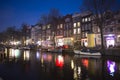 Water of canal in front of traditional Dutch houses in Amsterdam, Netherlands, March 23, 2019