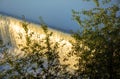 Water cascade on the Vltava river in Prague during early morning sun with vegetation in the foreground Royalty Free Stock Photo