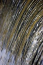 Water cascade waterfall streaming torrent splashes background, large detailed vertical closeup, bright blue, golden, yellow Royalty Free Stock Photo