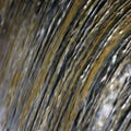 Water cascade waterfall streaming torrent splashes background, large detailed vertical closeup, bright blue, golden, yellow Royalty Free Stock Photo