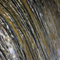 Water cascade waterfall streaming torrent splashes background, large detailed vertical closeup, bright blue, golden, yellow Royalty Free Stock Photo