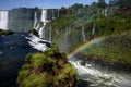 Water cascading over the Iguacu falls with rainbow in the foreground in Brazil Royalty Free Stock Photo