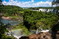 Water cascading over the Iguacu falls with rainbow in foreground in Brazil Royalty Free Stock Photo