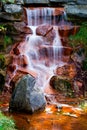 Water Cascading Over Red Algae Covered Rocks