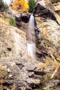 Water cascading over rocks, waterfall and autumn colors in the mountains, yellow and red trees Royalty Free Stock Photo