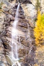 Water cascading over rocks, waterfall and autumn colors in the mountains, yellow and red trees Royalty Free Stock Photo