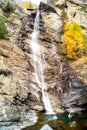 Water cascading over rocks, waterfall and autumn colors in the mountains, yellow and red trees Royalty Free Stock Photo