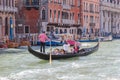 Water channels of Venice city. Gondolier rolls tourists on the gondola on Grand Canal in Venice, Italy